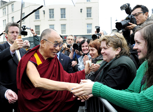 The Dalai Lama greets well-wishers as he leaves Edinburgh's Usher Hall after his formal visit