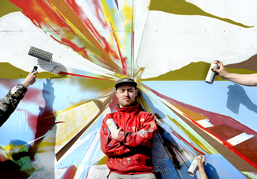 Artist Ali Wyllie at the 'vortex' of a seascape mural at a disused electricity sub-station at Stranraer Harbour