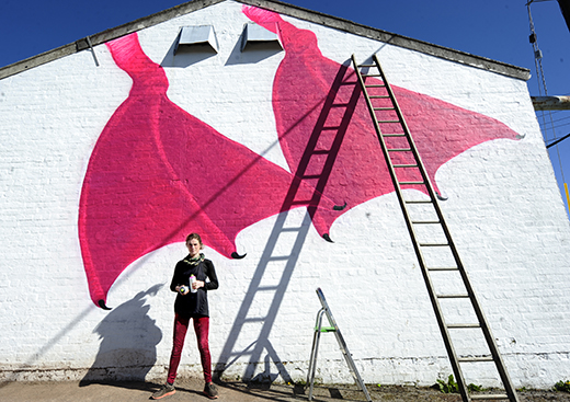 Alice Francis at her goose mural at the gable end of a barn at Torr Farm near Auchencairn