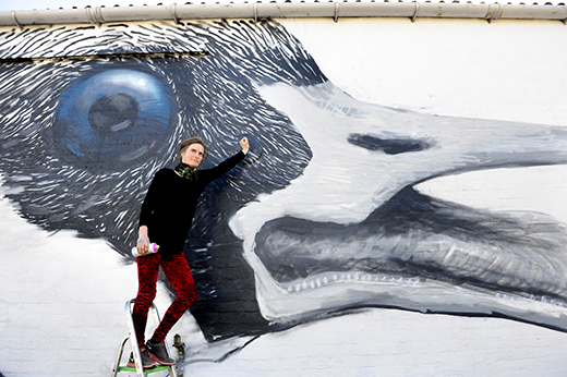 Alice Francis at her goose mural at the gable end of a barn at Torr Farm near Auchencairn